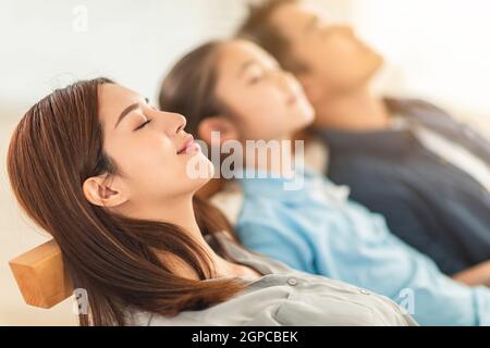 la famiglia gode di un tranquillo riposo respirando aria fresca a casa comodo divano Foto Stock