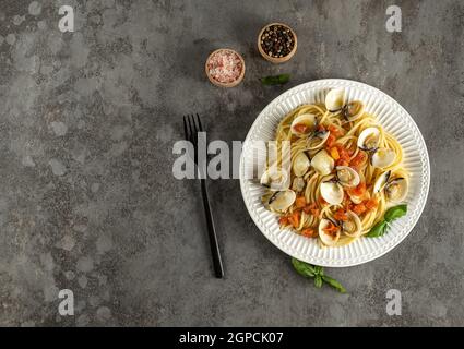 Gustosi appetitosi vongole fresche fatte in casa vongole pasta di pesce con pomodori, aglio e vino bianco Foto Stock