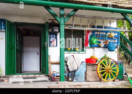 Particolare di casetta rurale cortile interno con attrezzatura colorata per il giardinaggio in portico in legno, Budakalasz, Ungheria Foto Stock