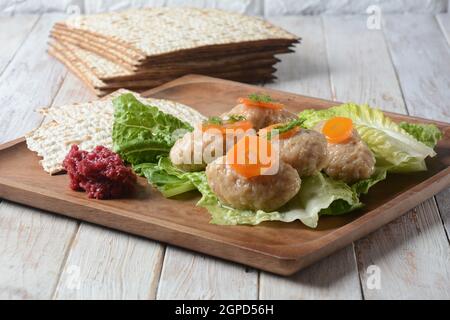 Passover tradizionale cibo ebraico - pesce di gefilte con carote, lattuga, rafano di cavallo e matza. Concetto di festa di Pasqua Foto Stock