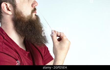 Test autodiagnostico del coronavirus a casa. Il giovane esegue un test rapido a casa con il covid-19. Test con tampone di cotone nel naso del giovane su backgroun bianco Foto Stock