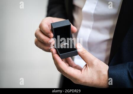 Groom holing bei moderni anelli di cerimonia nuziale con la scatola di monili aperta prima della cerimonia nuziale. Foto Stock