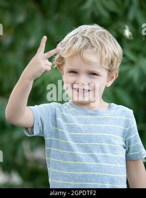 Bambino felice con blu t-shirt giocando in giardino Foto Stock