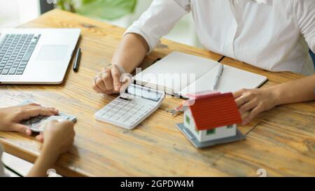 Un broker o agente immobiliare professionale discute ed esegue un contratto di affitto con un cliente in ufficio Foto Stock