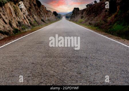 Strada solitaria con un cielo mozzafiato sullo sfondo Foto Stock