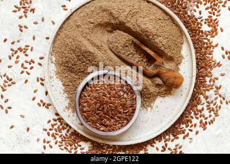 Farina di semi di Flax crudo in un piatto di ceramica con un vista dall'alto del cucchiaio Foto Stock