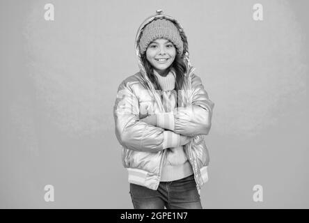 felice capretto in giacca di puffer d'argento e maglieria ottenere caldo in inverno pronto per l'attività in vacanza, vacanze di natale Foto Stock