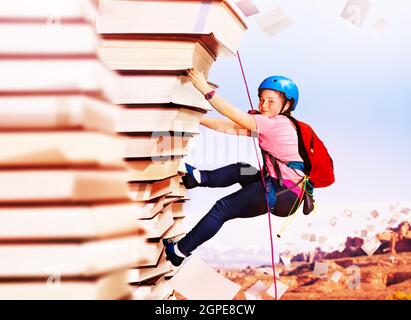 Ragazza roccia salire sulla montagna di libri di conoscenza Foto Stock