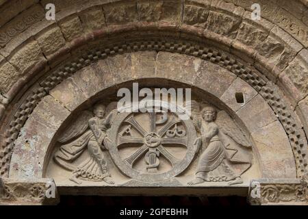 Particolare delle figure degli angeli in rilievo e del jaques a scacchi, nel portico ornato del monastero di San Pedro el Viejo, Huesca, Spagna Foto Stock