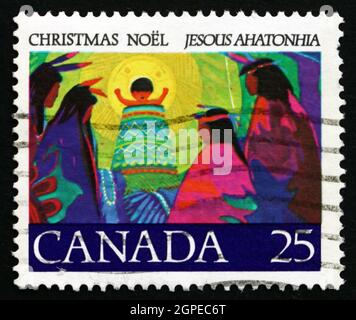 CANADA - CIRCA 1977: Un francobollo stampato in Canada mostra Cristo Bambino in anello di Gloria Benedizione Chiefs da Afar, Illustrazione per il primo CHRI del Canada Foto Stock