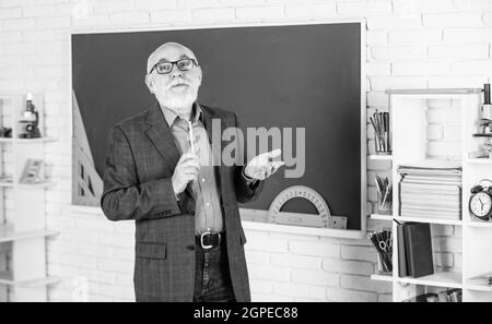 Torna a scuola. Insegnante di vecchia generazione di scuola. Docente esperto. Insegnante maturo che gode di lavoro. Condivisione delle conoscenze. Ulteriori strumenti introdotti in Foto Stock