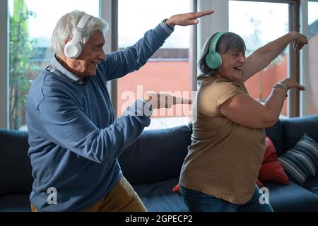 I nonni sono molto gentili e si tengono in forma ballando a casa nel soggiorno. Gli anziani svolgono attività salutari a casa. Foto Stock