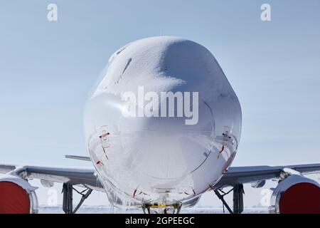 Pozzetto coperto di neve di velivolo commerciale. Vista frontale dell'aereo dopo la nevicata Foto Stock