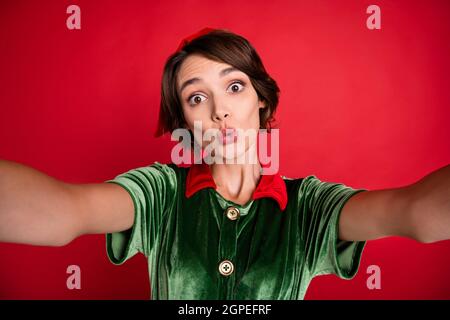 Foto di stupito shocked giovane donna positiva tenere mano fotocamera selfie natale isolato su sfondo rosso colore Foto Stock