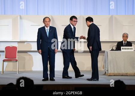 TOKYO, GIAPPONE - SETTEMBRE 29: Il primo ministro uscente, Yoshihide Suga (L), si ferma mentre Taro Kono, il ministro giapponese per la riforma della regolamentazione e il vaccino e un candidato alla leadership fallito (C), batte l'ex ministro degli Esteri giapponese Fumio Kishida dopo che Kishida è stato annunciato il vincitore delle elezioni di leadership del Partito Liberal-democratico il 29 settembre 2021 a Tokyo, Giappone. La sostituzione del primo Ministro Sha sarà il terzo leader del Giappone durante la pandemia di coronavirus ed è probabile che si concentrerà fortemente sul ritorno dell'economia del paese sulla strada. (Foto di Carl Court/Getty Images) Foto Stock