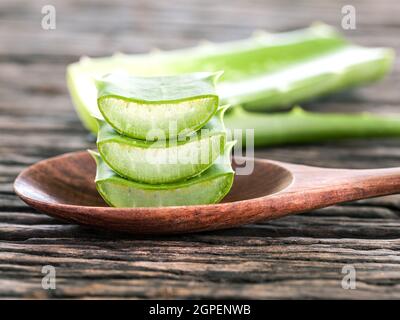 Aloe Vera fetta terme naturali ingredienti per la cura della pelle su sfondo di legno. Foto Stock