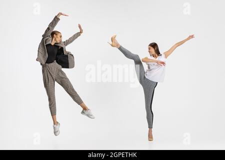 Due donne, dipendenti in abiti casual ballando isolato su sfondo bianco. Ballerine Foto Stock