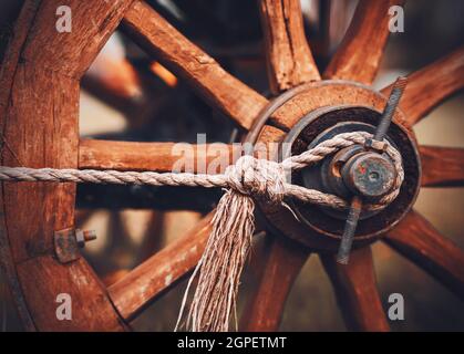 Una vecchia ruota di legno da un carrello che è stato utilizzato per la raccolta nel primo piano villaggio. Trasporto del passato. Agricoltura e la contadina. Foto Stock