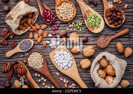 Legumi vari e diversi tipi di nutshells in cucchiai. I kernel di noci, nocciole, mandorle ,brown pinto ,i fagioli di soia ,semi di lino ,chia ,cece ,ri Foto Stock