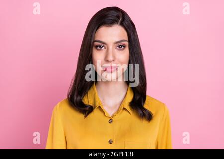 Foto di bruna carino hairdo millennial donna indossare camicia gialla isolato su sfondo rosa Foto Stock