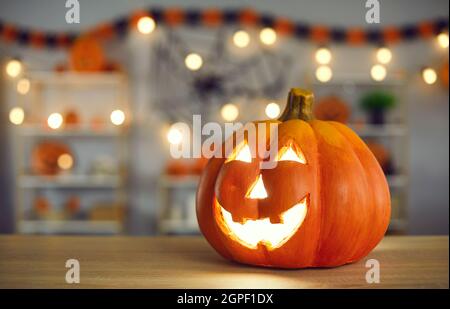 Halloween sfondo con smiley Jack-o-lanterna con candela bruciante all'interno sul tavolo Foto Stock