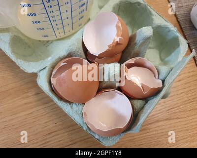 Quattro gusci d'uovo rotti in un imballaggio di cartone per uova sono stati usati come ingrediente di cottura e pronti per essere riciclati come rifiuti alimentari Foto Stock