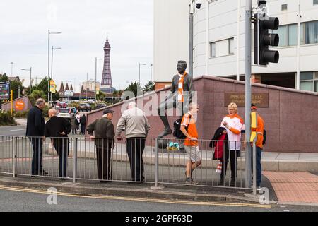I tifosi del Blackpool FC si riuniscono in una giornata di incontri accanto alla statua di Jimmy Armfield a Bloomfield Road con la Blackpool Tower in lontananza. Visto a Septembo Foto Stock