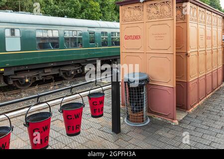 I secchi del fuoco GWR e un orinatoio in ghisa del XIX secolo che è stato restaurato dalla ferrovia della valle di Severn ed è in uso sulla stazione di Bewdley Foto Stock