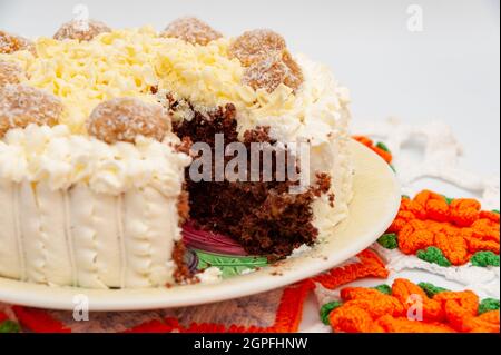 Deliziosa torta al cioccolato ripiena fatta in casa decorata con cioccolato bianco grattugiato e tartufi di noce di cocco fuge dulce de leche. Foto Stock