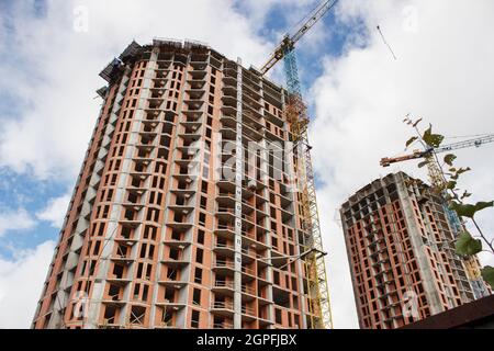 costruzione di un alto edificio residenziale a più piani in città il giorno d'estate Foto Stock