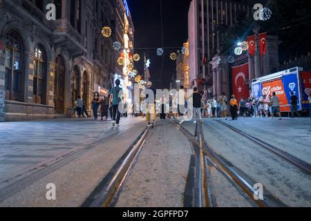 Beyoglu, Istanbul, Turchia - 07.07.2021: Molti turchi che camminano su Istiklal Independence Street di notte come gruppi e negozi con luci lucenti Foto Stock