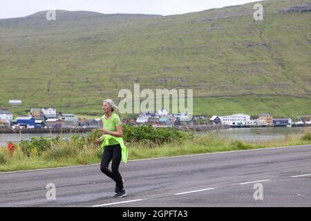 Donna partecipante alla mezza maratona da Gasadalur a Sandav‡gur, Vagar Island, Isole Faroe, Europa. Foto Stock
