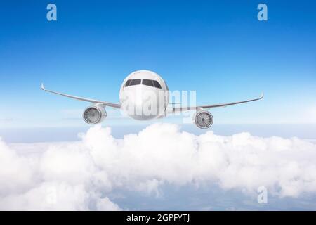 L'aeroplano vola sopra le nuvole di cumulo, esattamente vista frontale Foto Stock