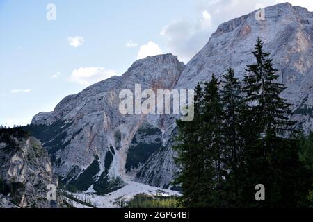 Le rocce della Croda del Becco scendono quasi a toccare l'acqua nella parte superiore del Lago di Braies Foto Stock