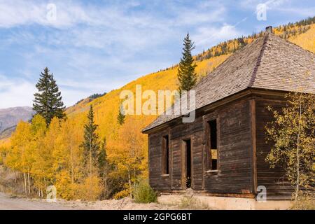 Vecchio edificio minerario abbandonato con gli alberi di aspen gialli nelle montagne Sun Juan del Colorado Foto Stock