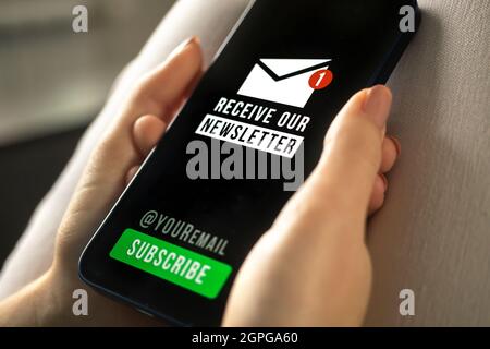 Telefono cellulare con newsletter registrazione pagina primo piano in mani donna Foto Stock