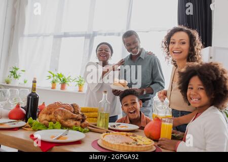 Famiglia afroamericana con bambini in piedi vicino cena di ringraziamento Foto Stock