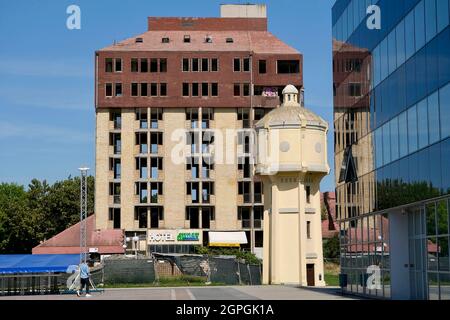 Croazia, Slavonia, Vukovar, l'hotel Dunav, in parte restaurato e poi abbandonato e la vecchia torre d'acqua Foto Stock