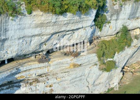 Francia, Dordogne, Perigord Noir, Vezere Valley, sito preistorico e grotta decorata elencati come Patrimonio Mondiale dell'UNESCO, Peyzac le Moustier, la Roque Saint Christophe Cliff, sito trogloditico risalente alla preistoria, medievale stack macchine ricostituzione sotto il riparo di roccia (vista aerea) Foto Stock