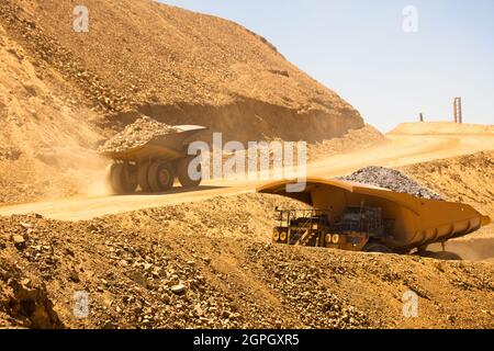 Enormi dumper caricati con minerali in una miniera di rame in Cile. Foto Stock