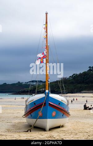 RNLI Lifeboat James Stevens No10 ormeggiato sulla spiaggia di St. Ives Harbour con bandiere Foto Stock