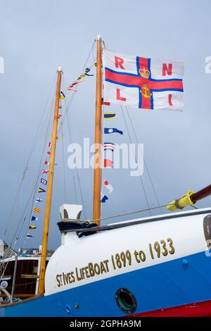 RNLI Lifeboat James Stevens No10 ormeggiato sulla spiaggia di St. Ives Harbour con bandiere Foto Stock
