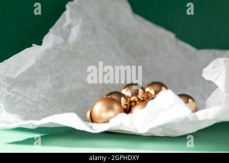 Decorazioni natalizie dorate in carta strappata su sfondo verde smeraldo Foto Stock