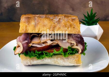 tacchino e pancetta con pomodori su pane ciabatta Foto Stock