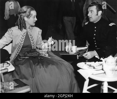 BETTE DAVIS e GEORGE BRENT sul set candid durante una pausa nelle riprese della VECCHIA CAMERIERA 1939 regista EDMUND GOULDING sceneggiatura Casey Robinson basato sul romanzo di Edith Wharton e gioco di Zoe Akins musica Max Steiner Costume design Orry-Kelly Warner Bros. Foto Stock