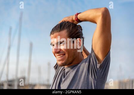 Giovane latino che si allunga dopo aver fatto esercizio all'aperto Foto Stock