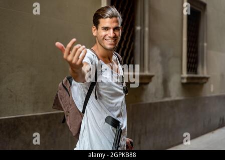 Giovane latino con stampelle che visitano la città Foto Stock