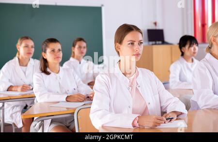 Studenti di medicina che scrivono in notepad Foto Stock