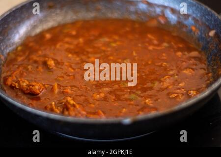 Primo piano di una padella con salsa di pomodoro in preparazione. Messa a fuoco selettiva. Pomodoro liquido per pizza o pasta. Foto Stock