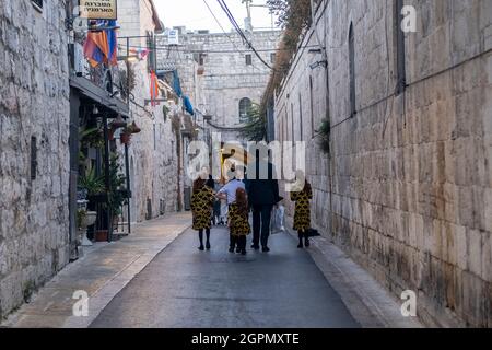 Gli ebrei ultraortodossi camminano sabato lungo la via del Patriarcato armeno nel quartiere armeno nella città vecchia di Gerusalemme Est Israele Foto Stock